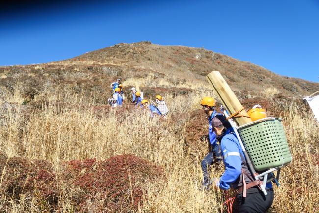 登山道整備班は、整備用の機材を背負って移動します