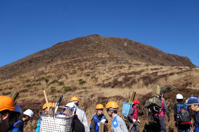 登山道整備班は、整備用の機材を背負って移動します