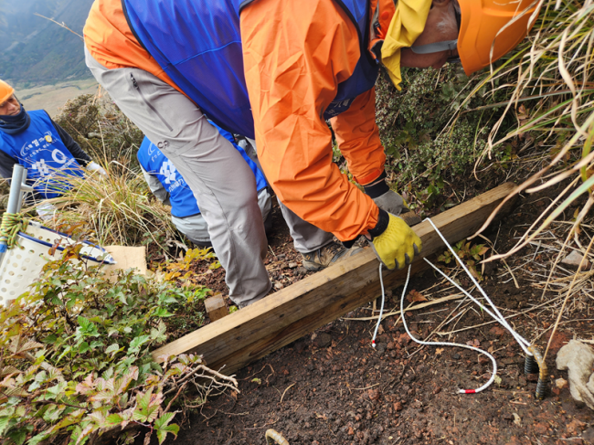 新工法(タイバックアンカー工法)による水切り板の設置作業①